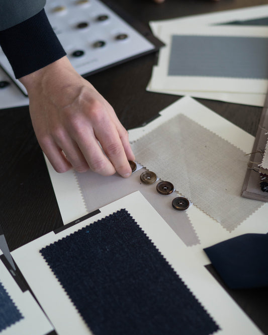 Tailor choosing some fabrics like wool, linen, cashmere and silk.