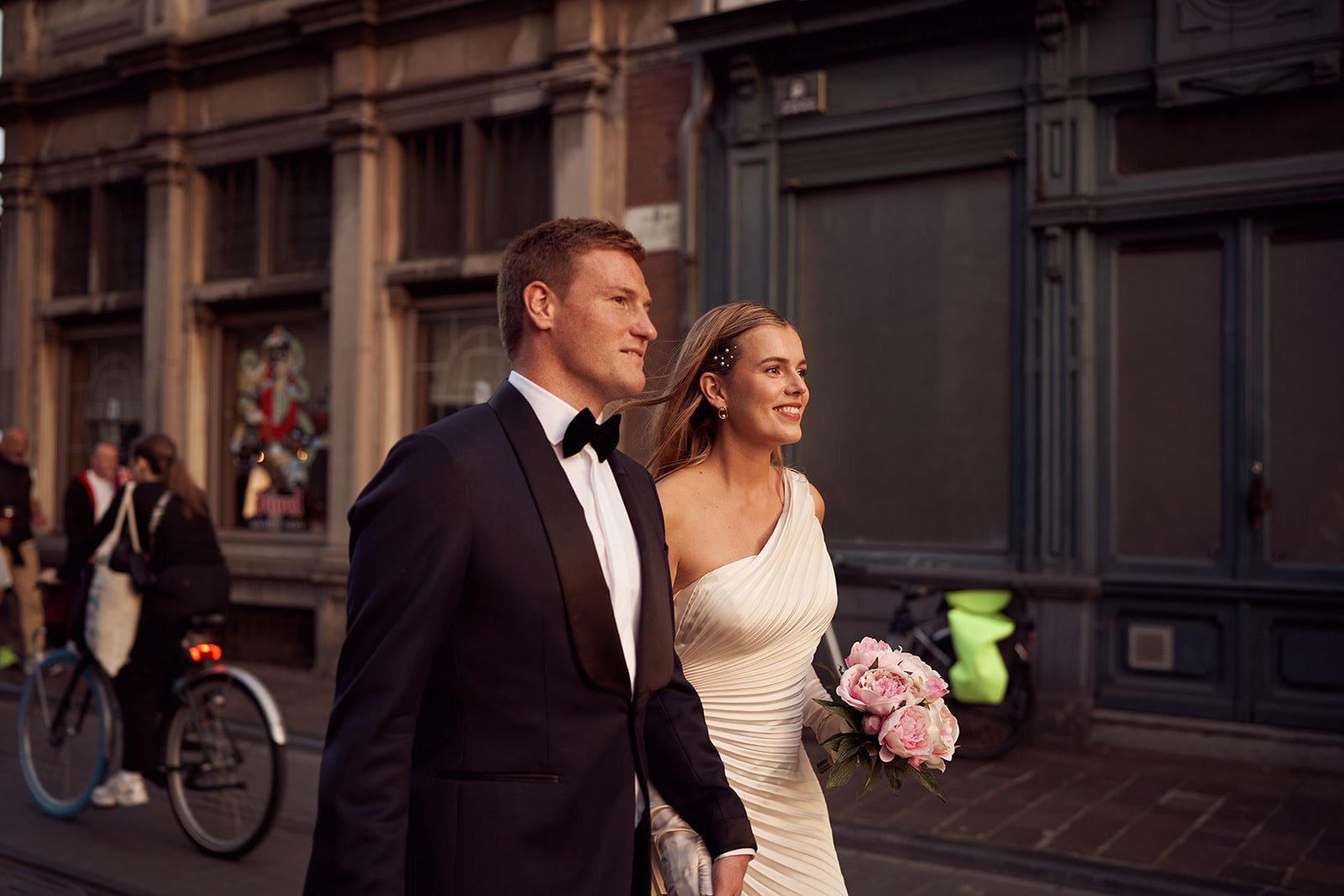 Newlywed couple celebrating, groom in a handcrafted Atelier ACÀN tuxedo.