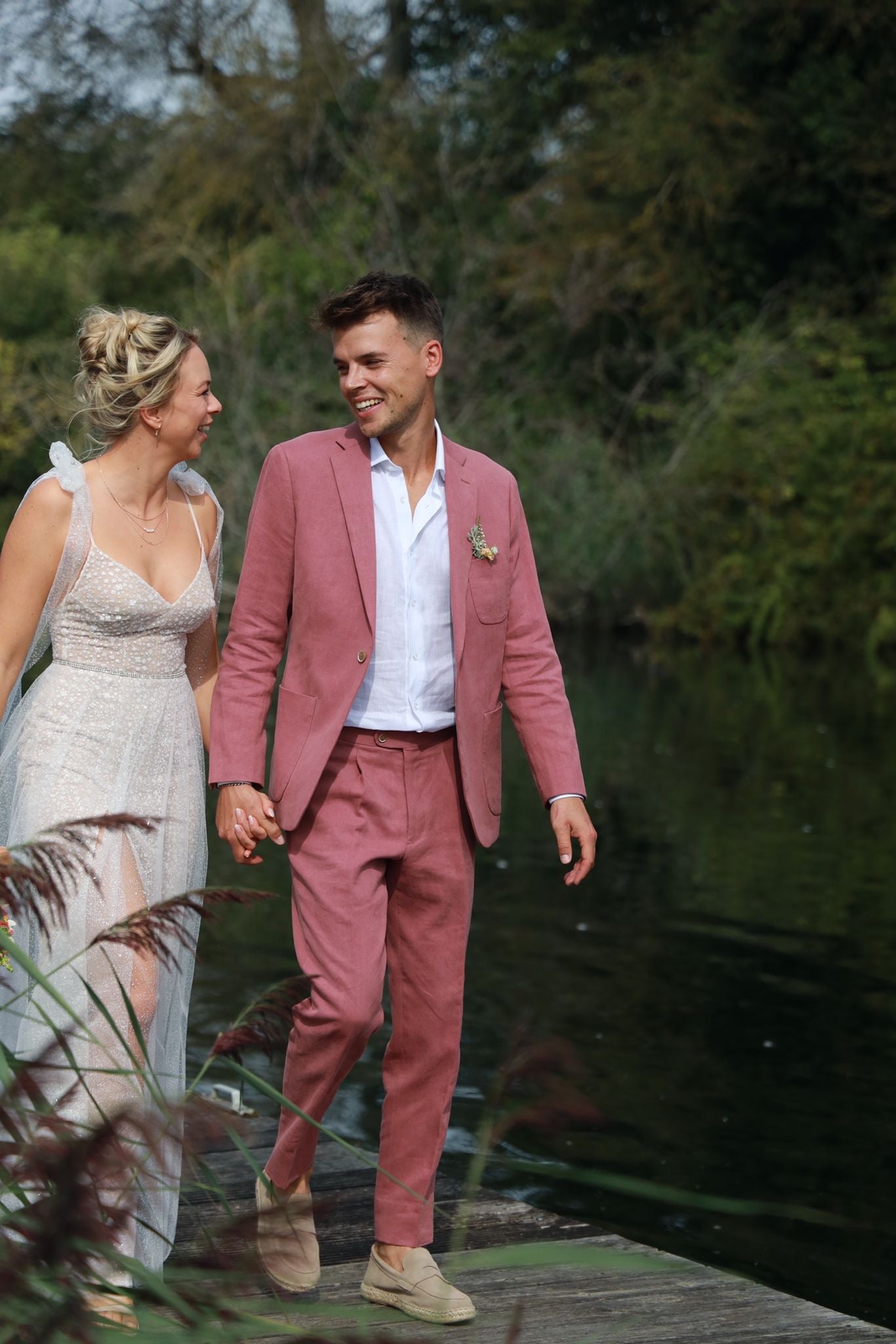 Newlywed couple celebrating, groom in a handcrafted Atelier ACÀN tuxedo.