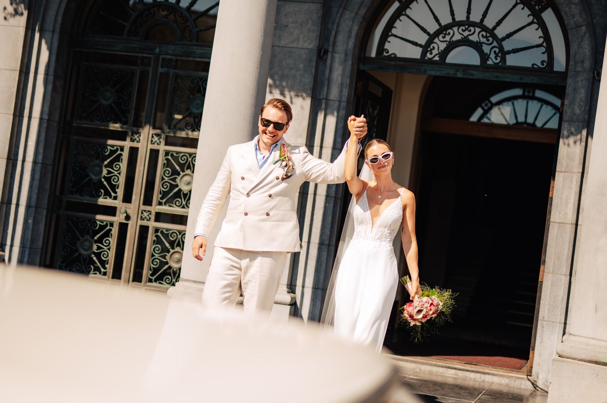 Newlywed couple celebrating, groom in a handcrafted Atelier ACÀN tuxedo.