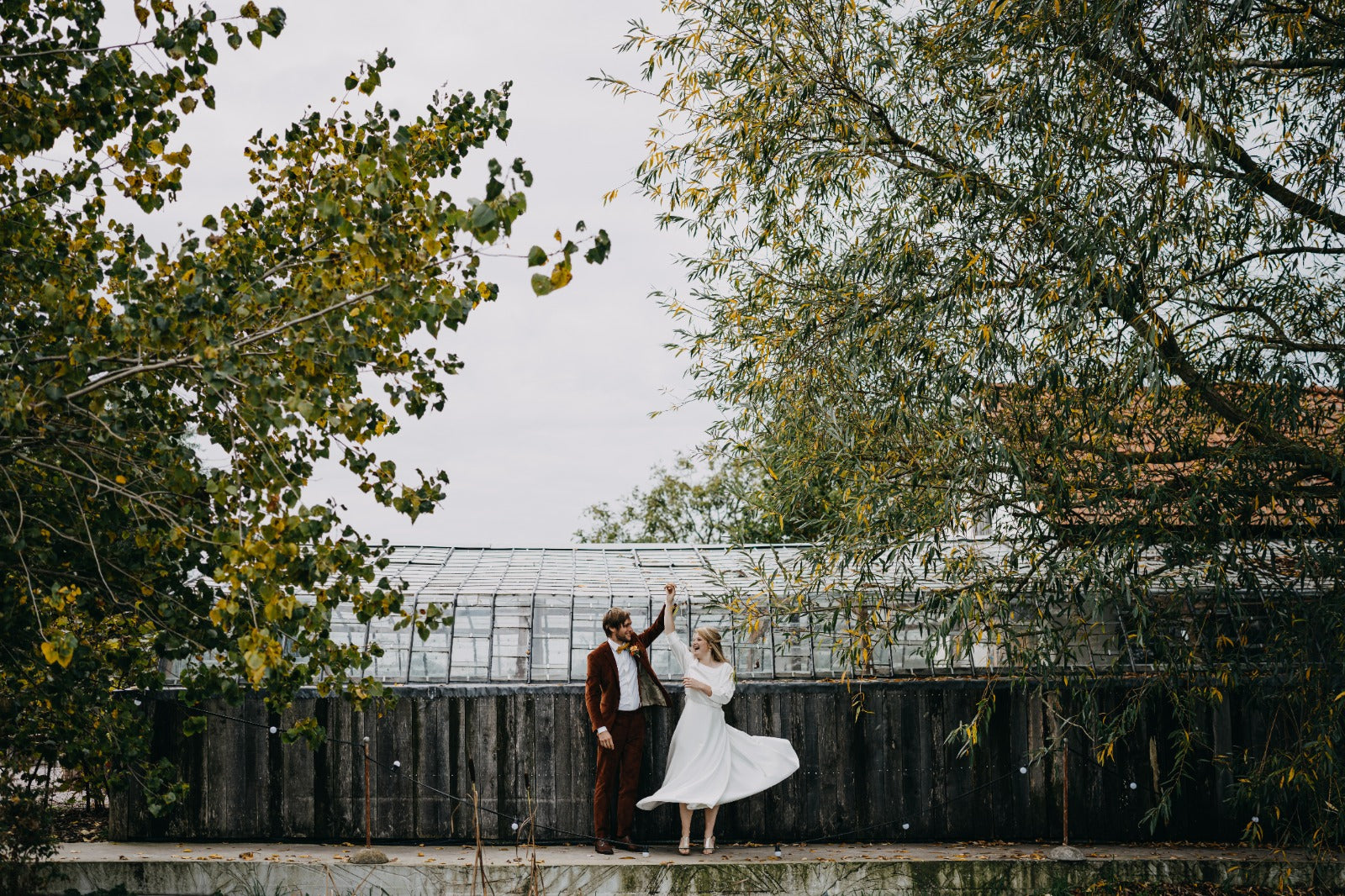 Newlywed couple celebrating, groom in a handcrafted Atelier ACÀN tuxedo.