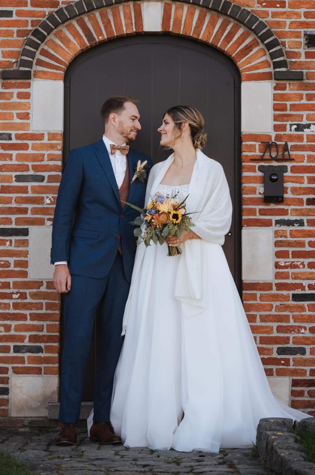 Newlywed couple celebrating, groom in a handcrafted Atelier ACÀN tuxedo.