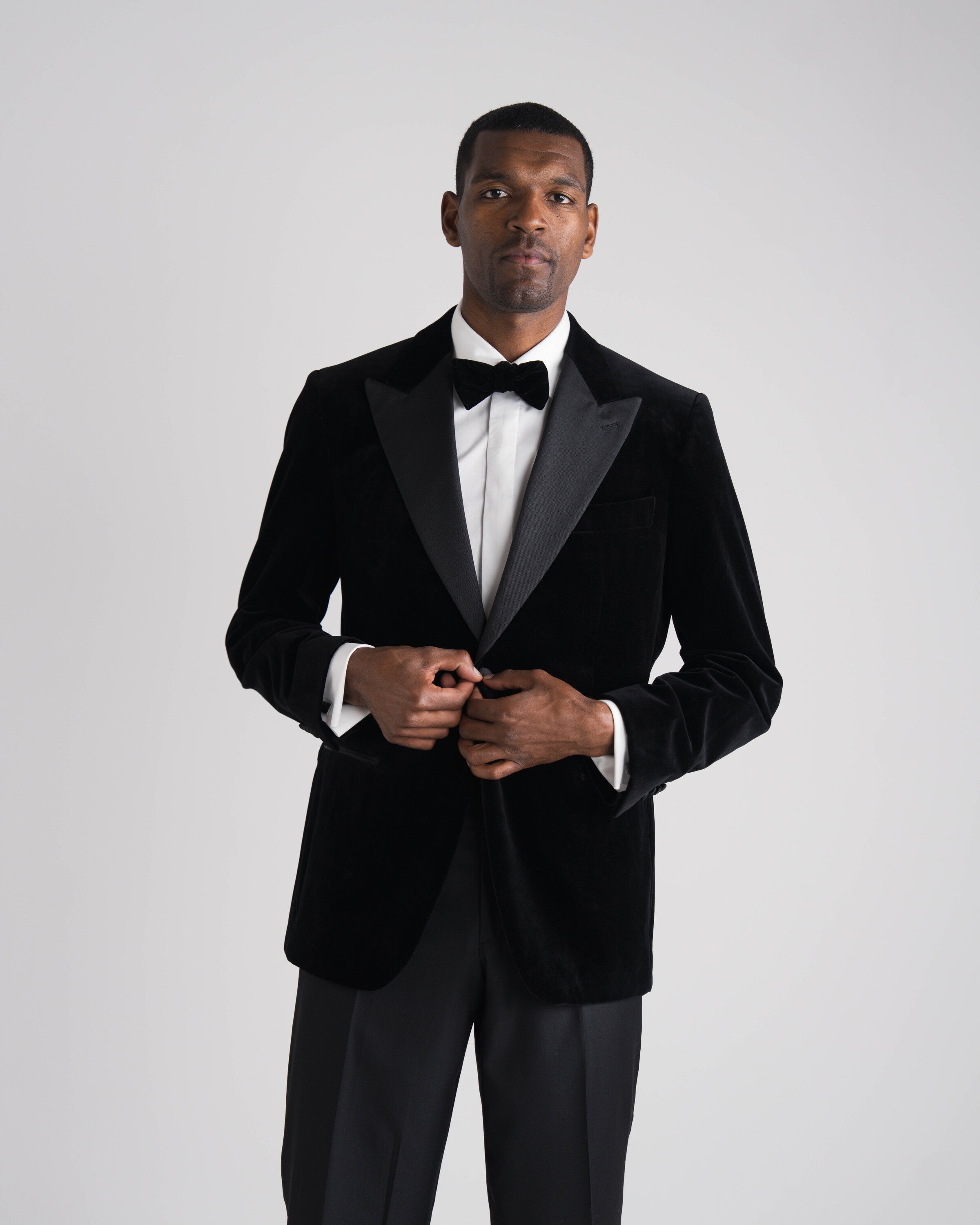 staande man in zwarte velvet tuxedo en zwarte strik