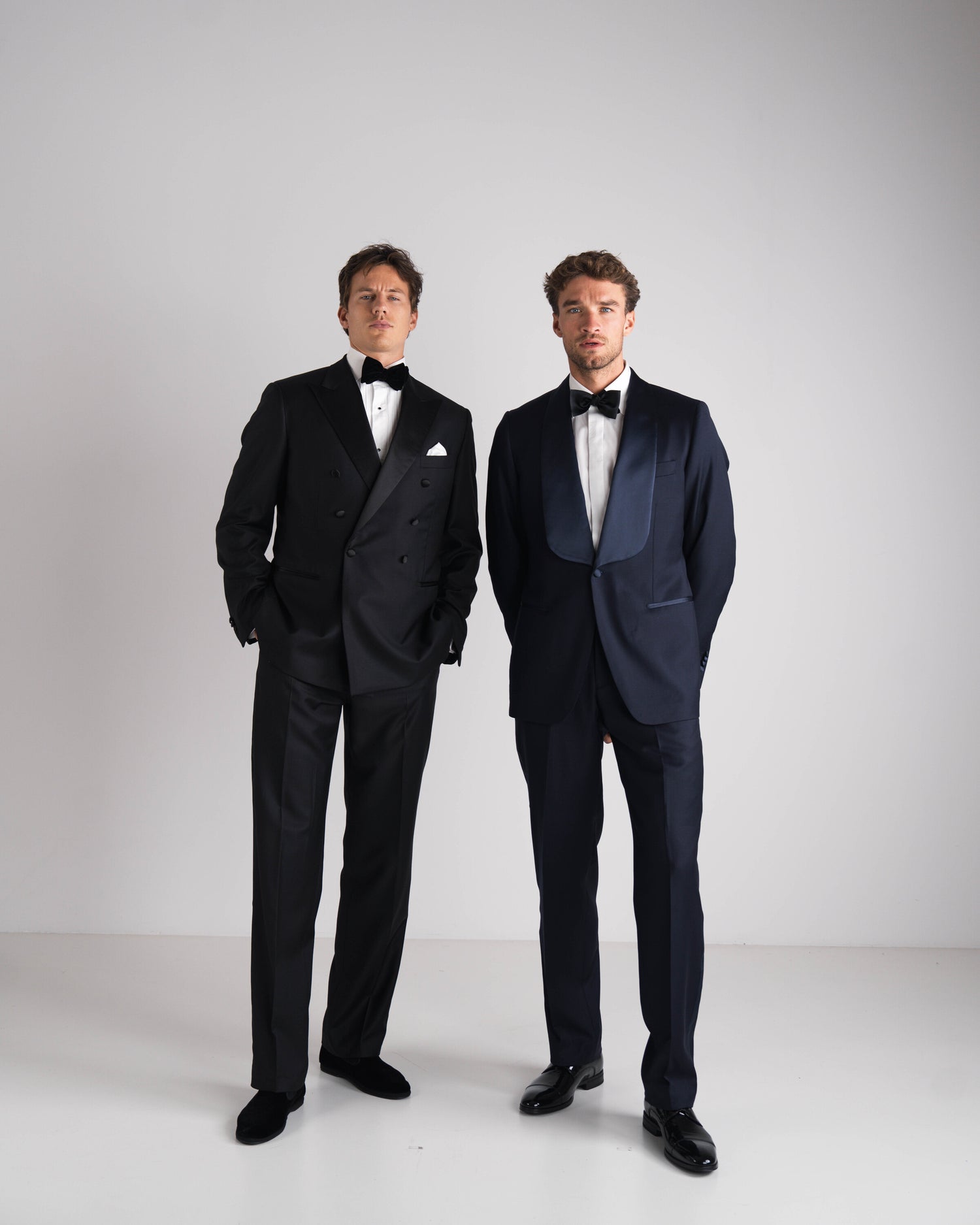 Een man in een double breasted zwarte smoking en een man in een donkerblauwe smoking op gemaakt bij Atelier ACÀN