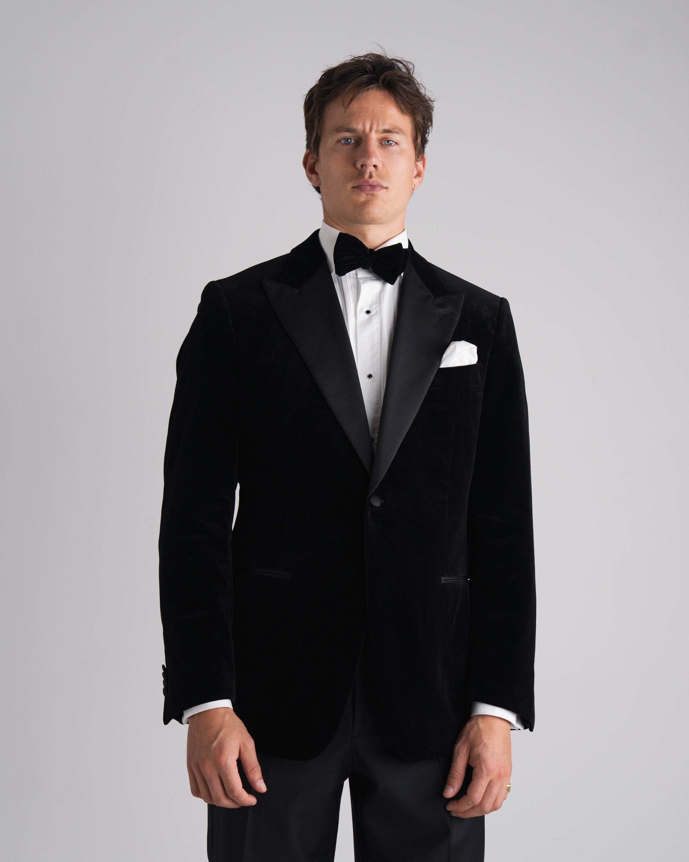 staande man in zwarte velvet tuxedo en zwarte strik