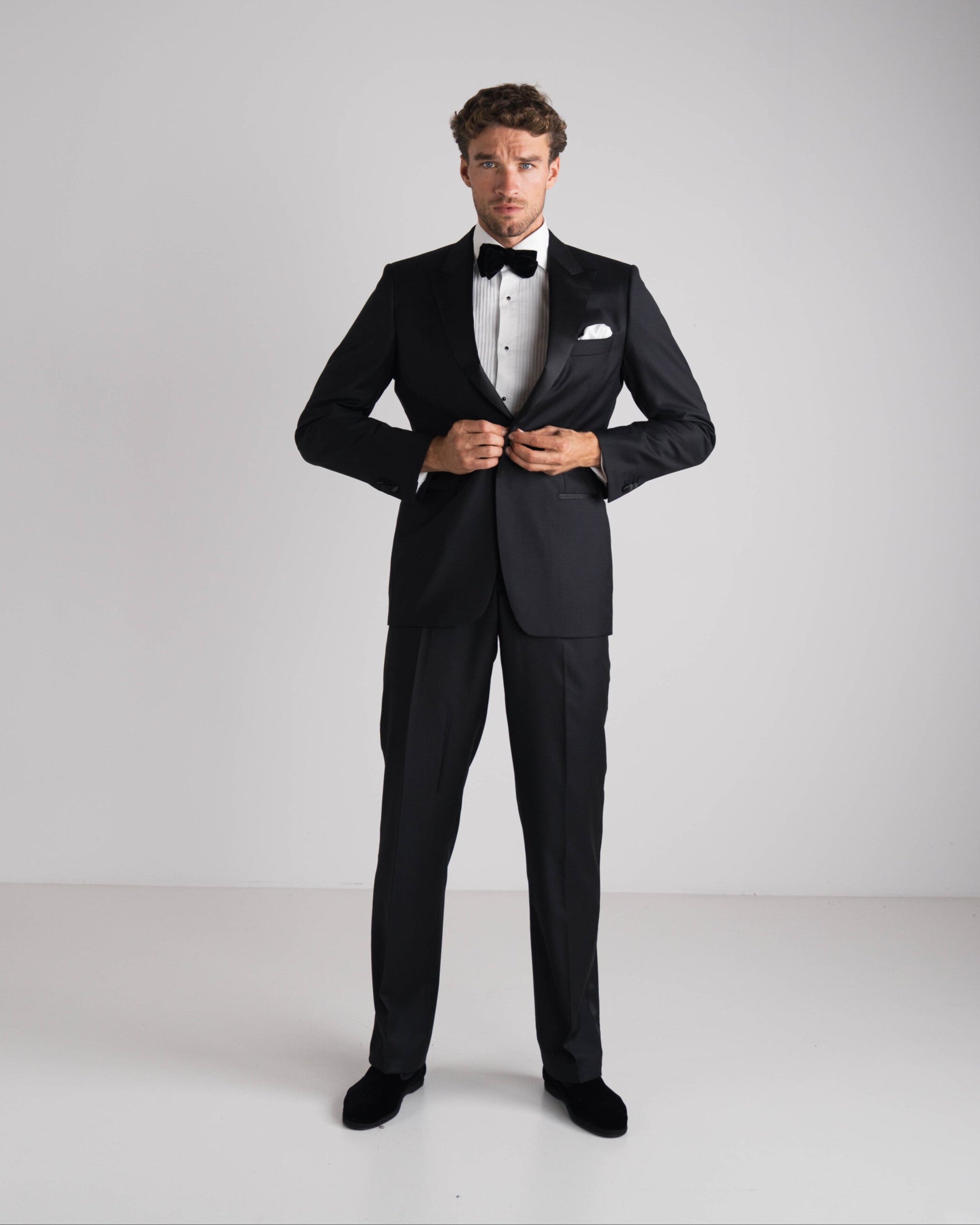 staande man in zwarte tuxedo met zwarte strik