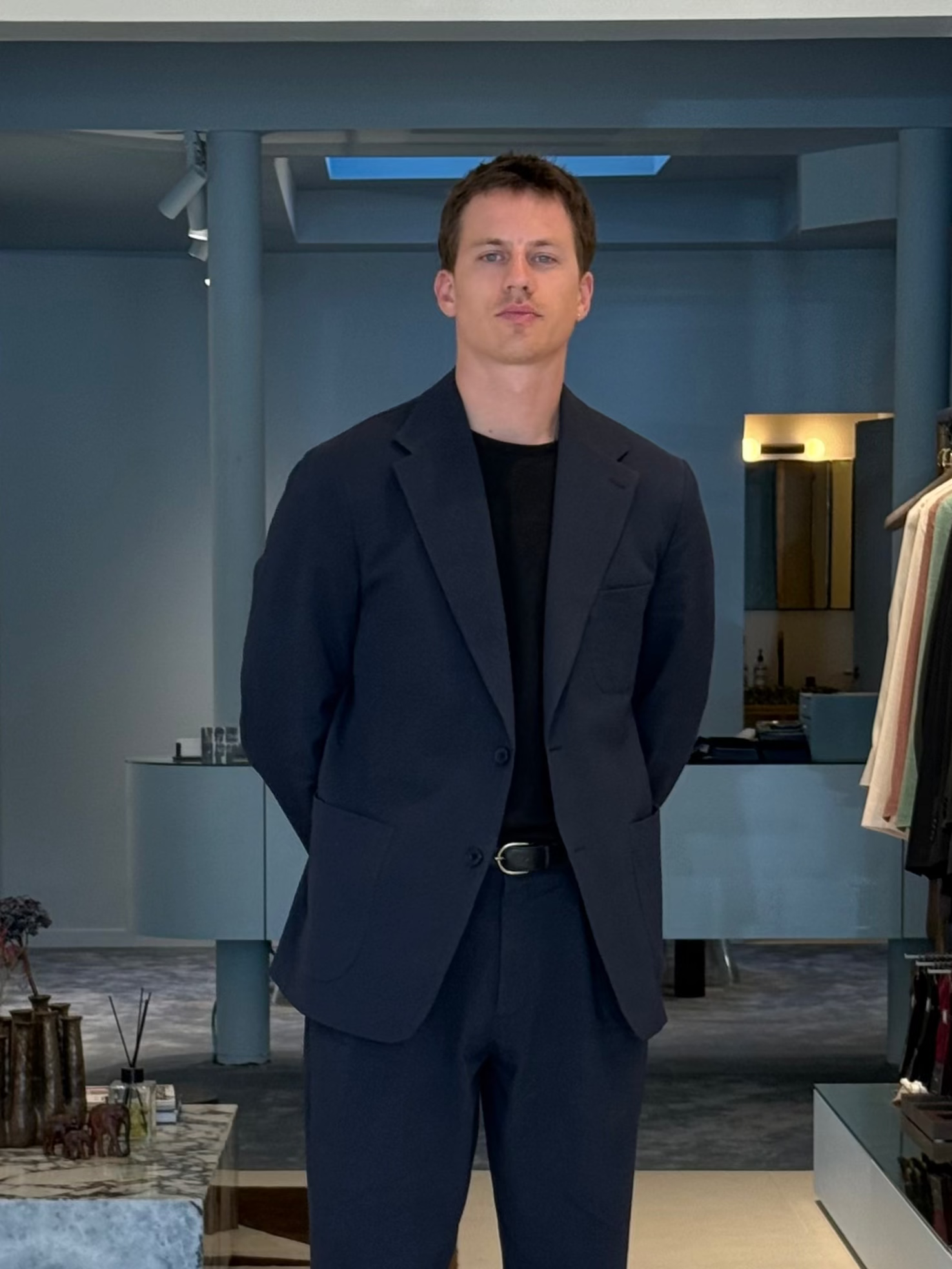 Tailor Pierre in his navy suit posing in the store in Antwerp.