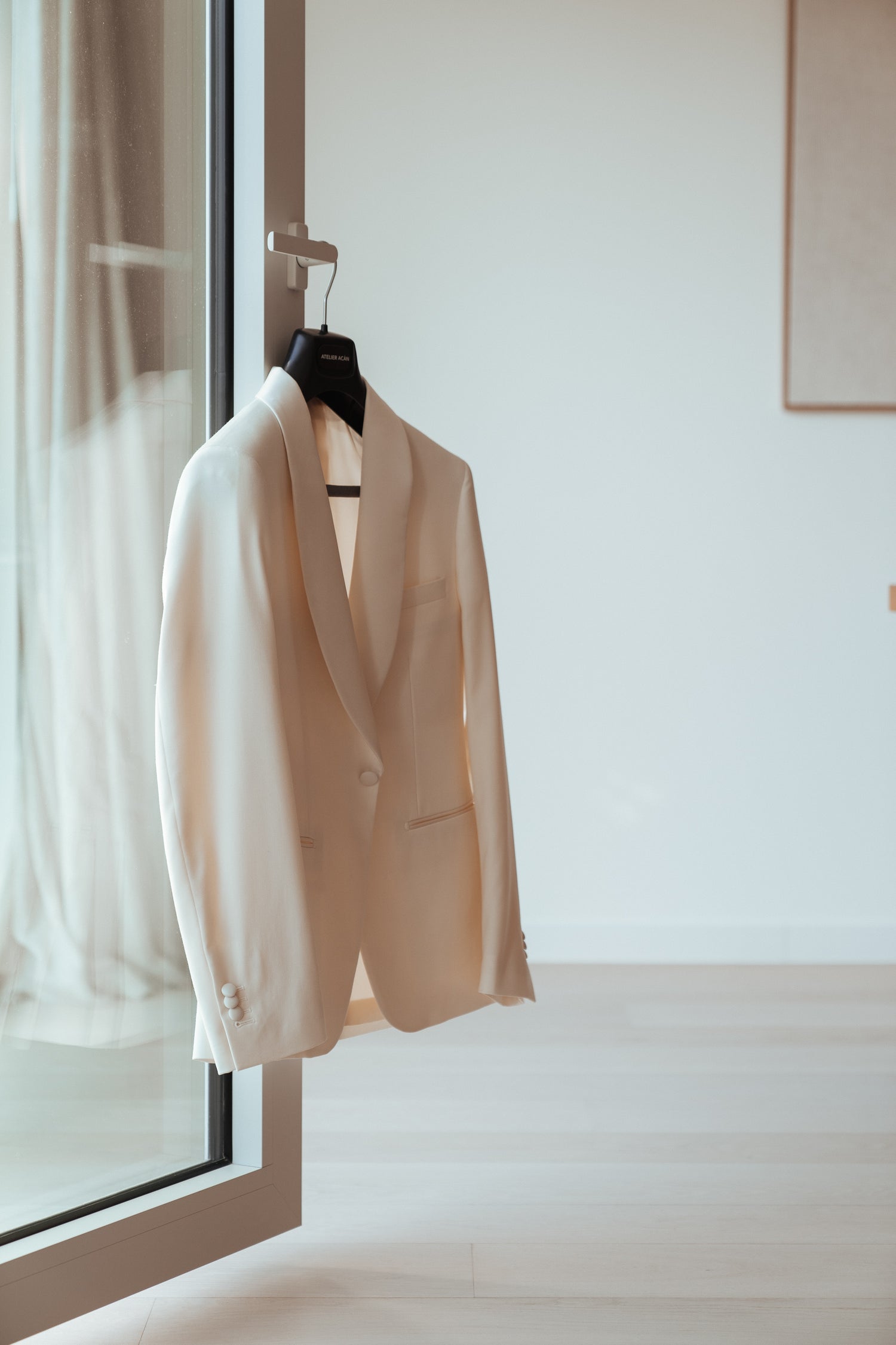 Witte smoking jas hangend aan de deur