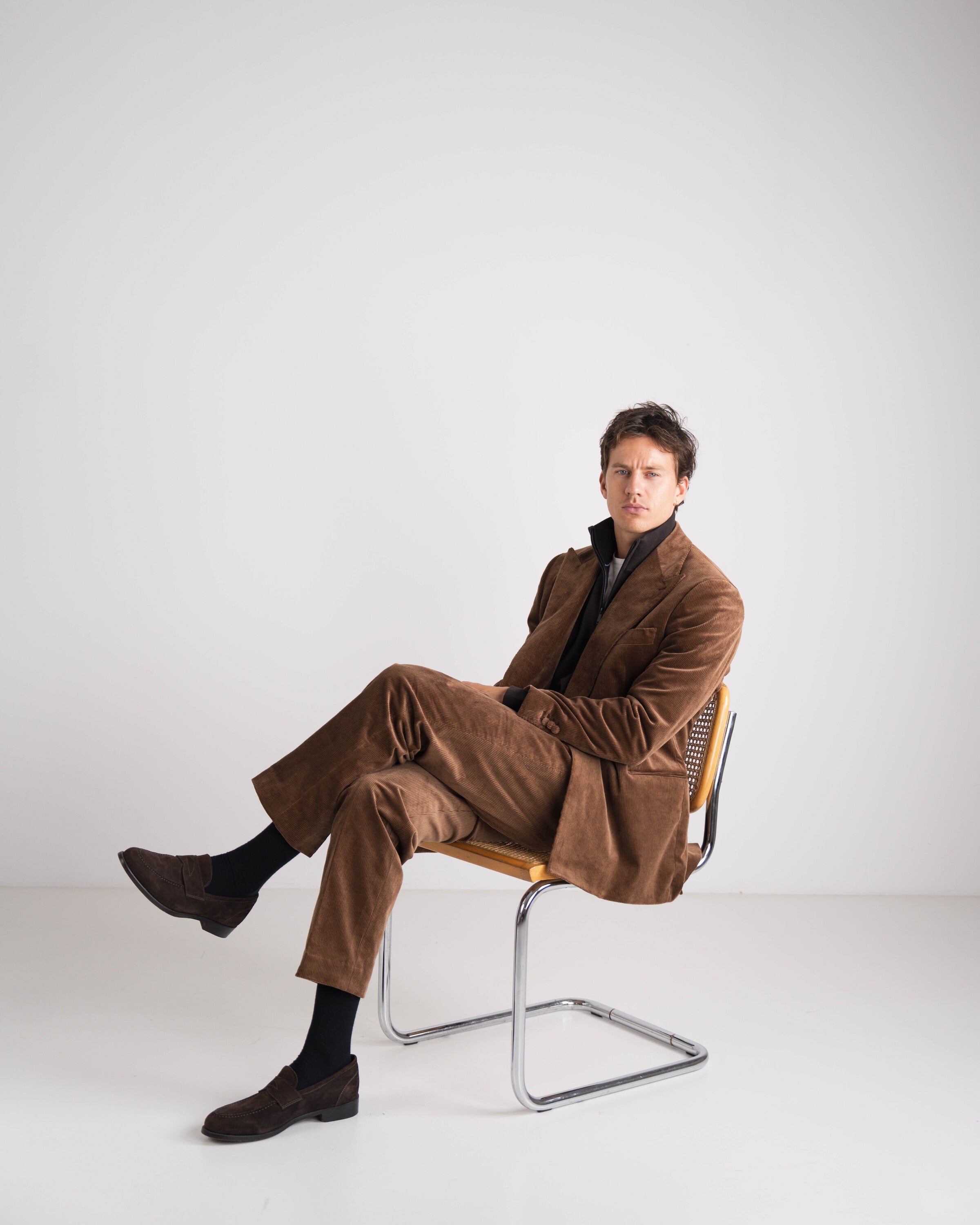 zittende man in bruin kostuum met bruine trui