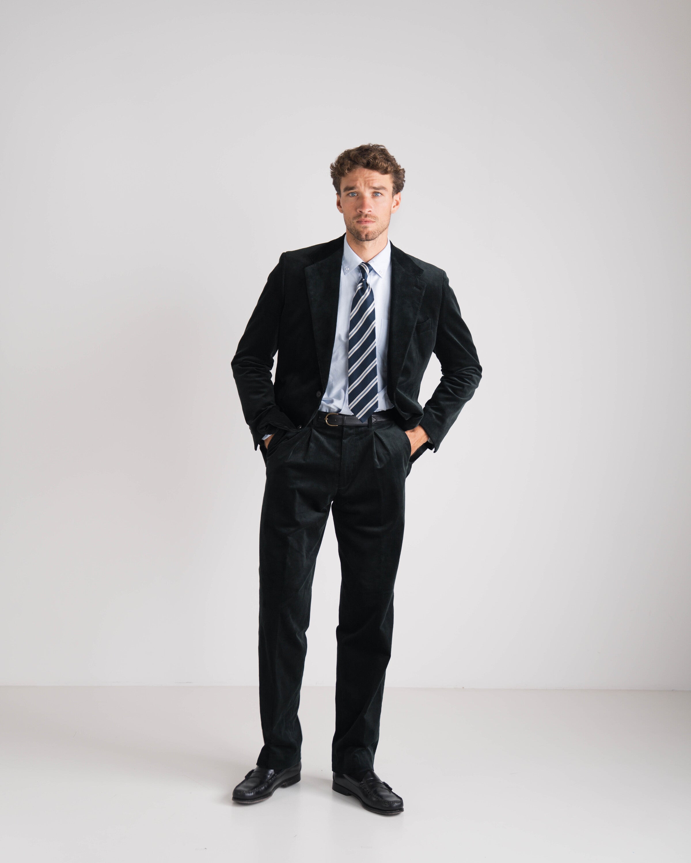 man met groen kostuum en blauw gestreepte das en blauw hemd