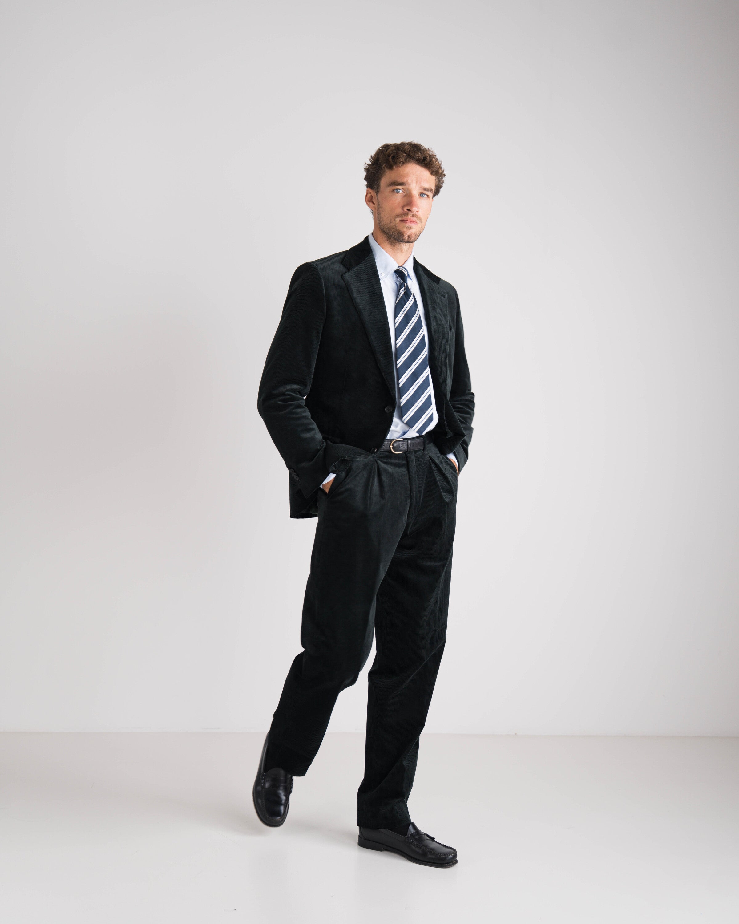 man met groen kostuum en blauw gestreepte das en blauw hemd