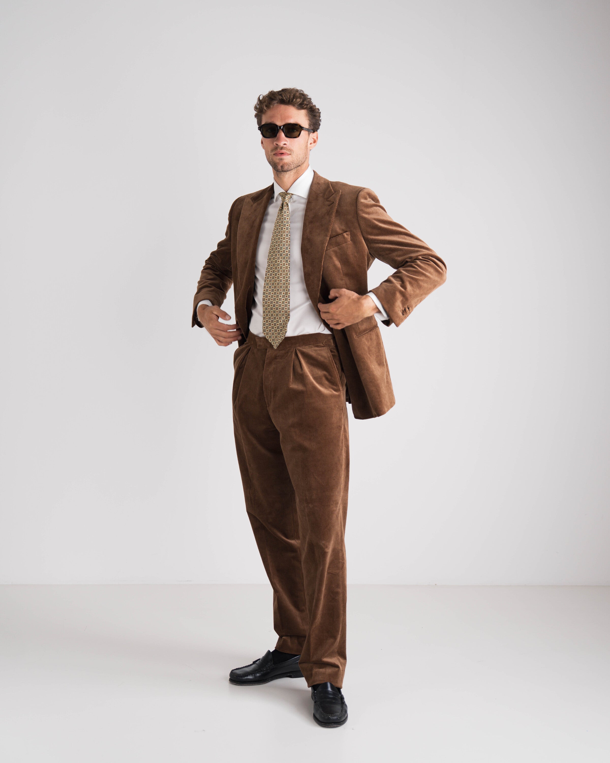 donkerbruin ribfluweel kostuum man met wit hemd en das