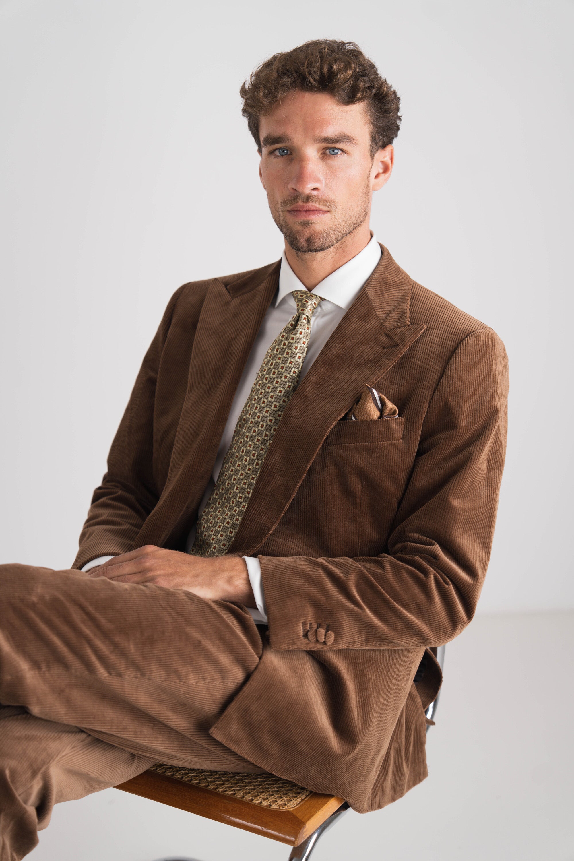 Man in bruin kostuum met beige groene das