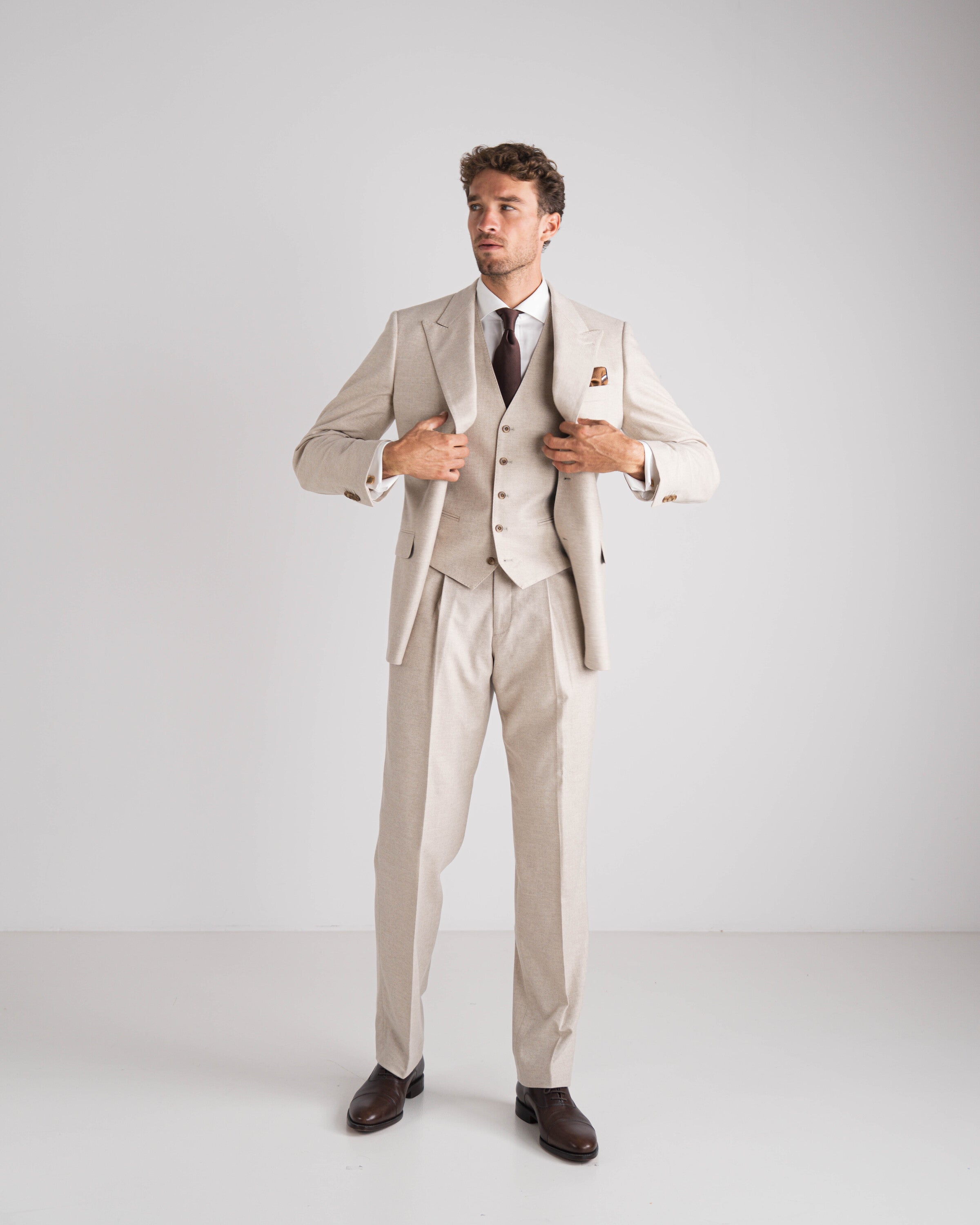 beige drie delig kostuum met bruine das en wit hemd