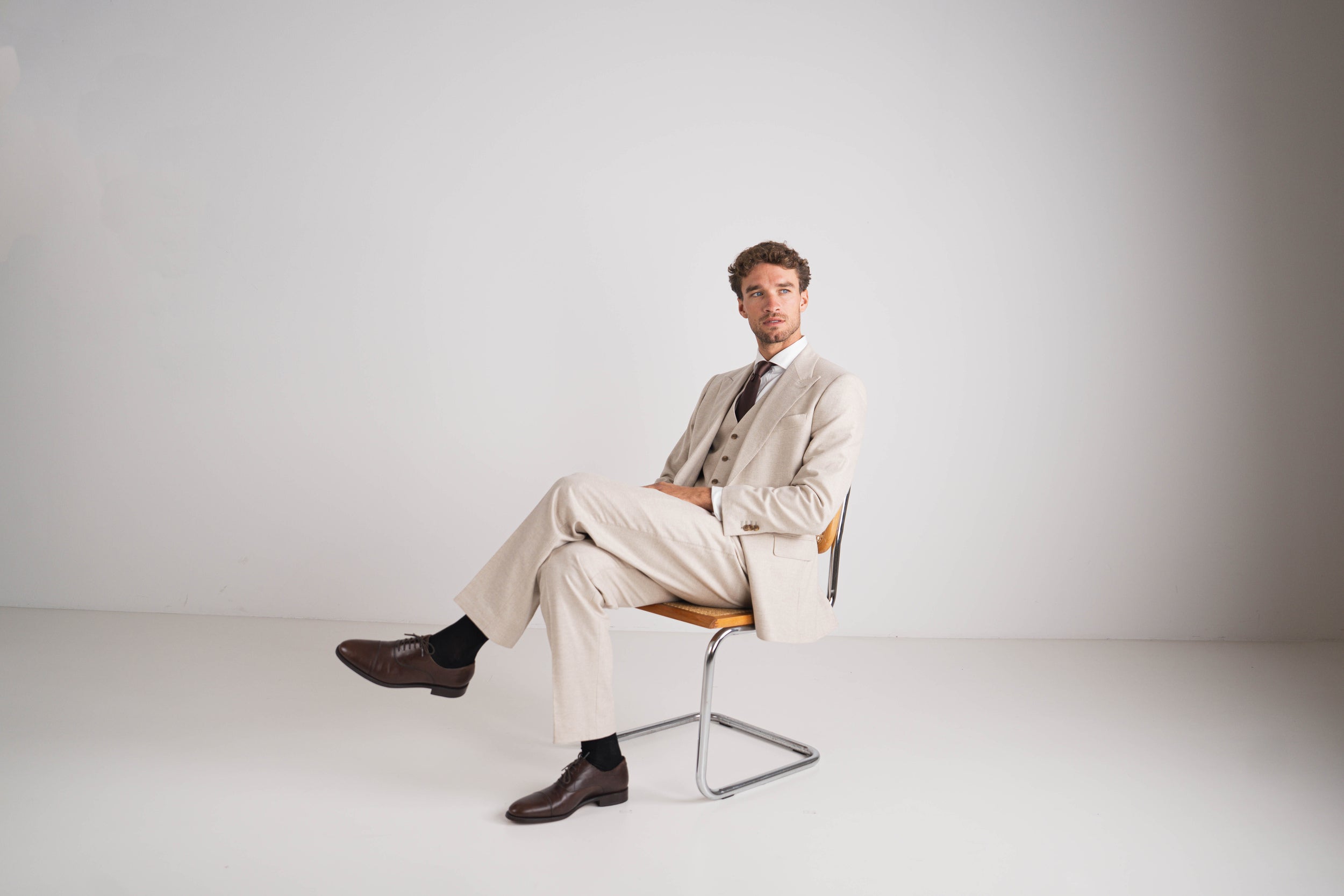 beige drie delig kostuum met bruine das en wit hemd