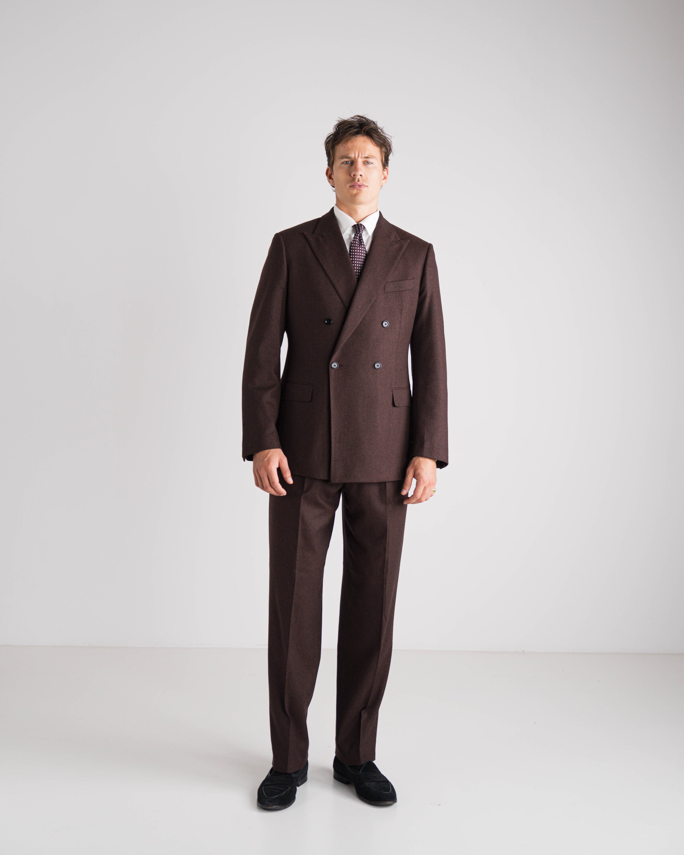 Man in een bordeaux double-breasted maatpak van Atelier ACÀN.