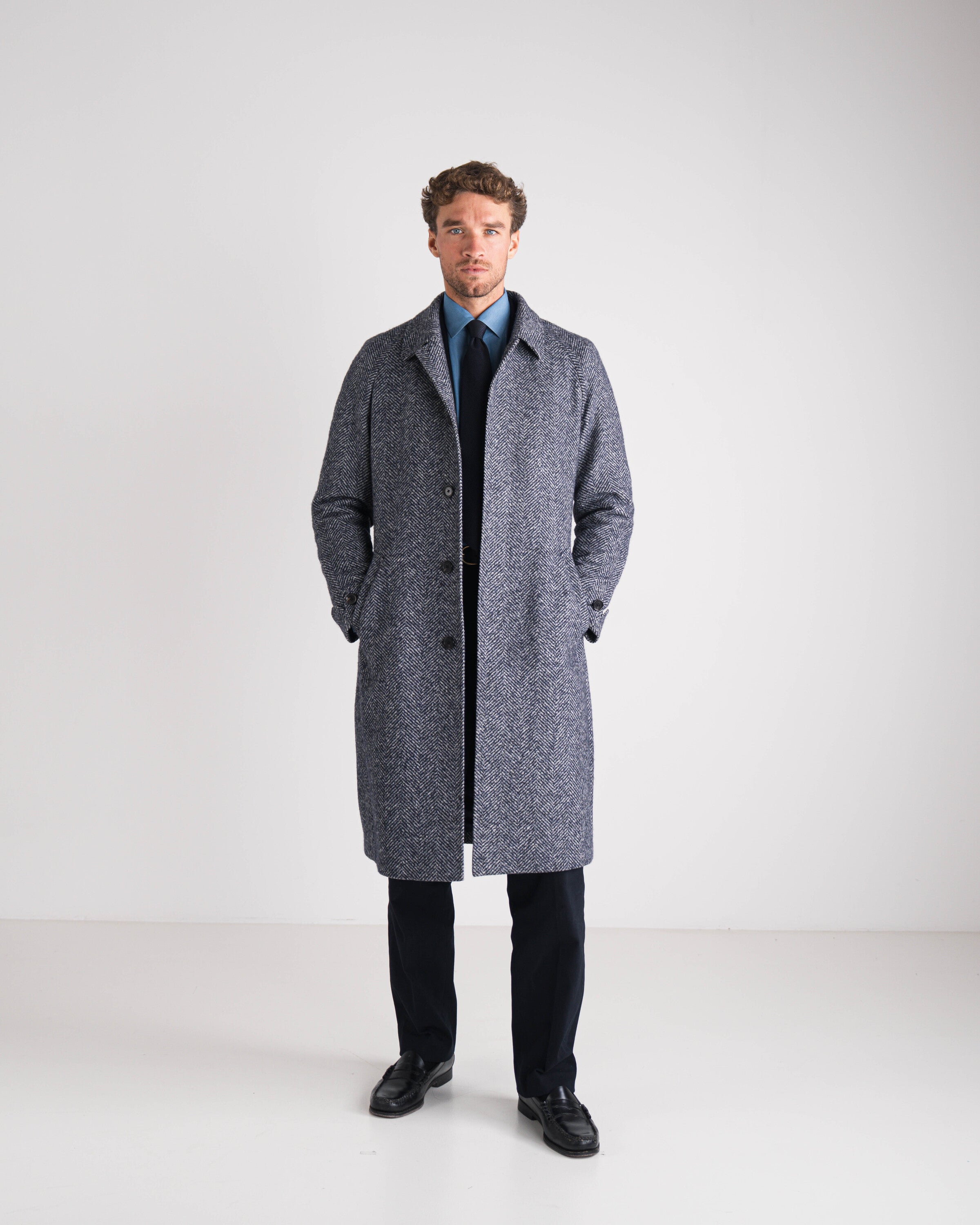 Man wearing a gray coat on a white background