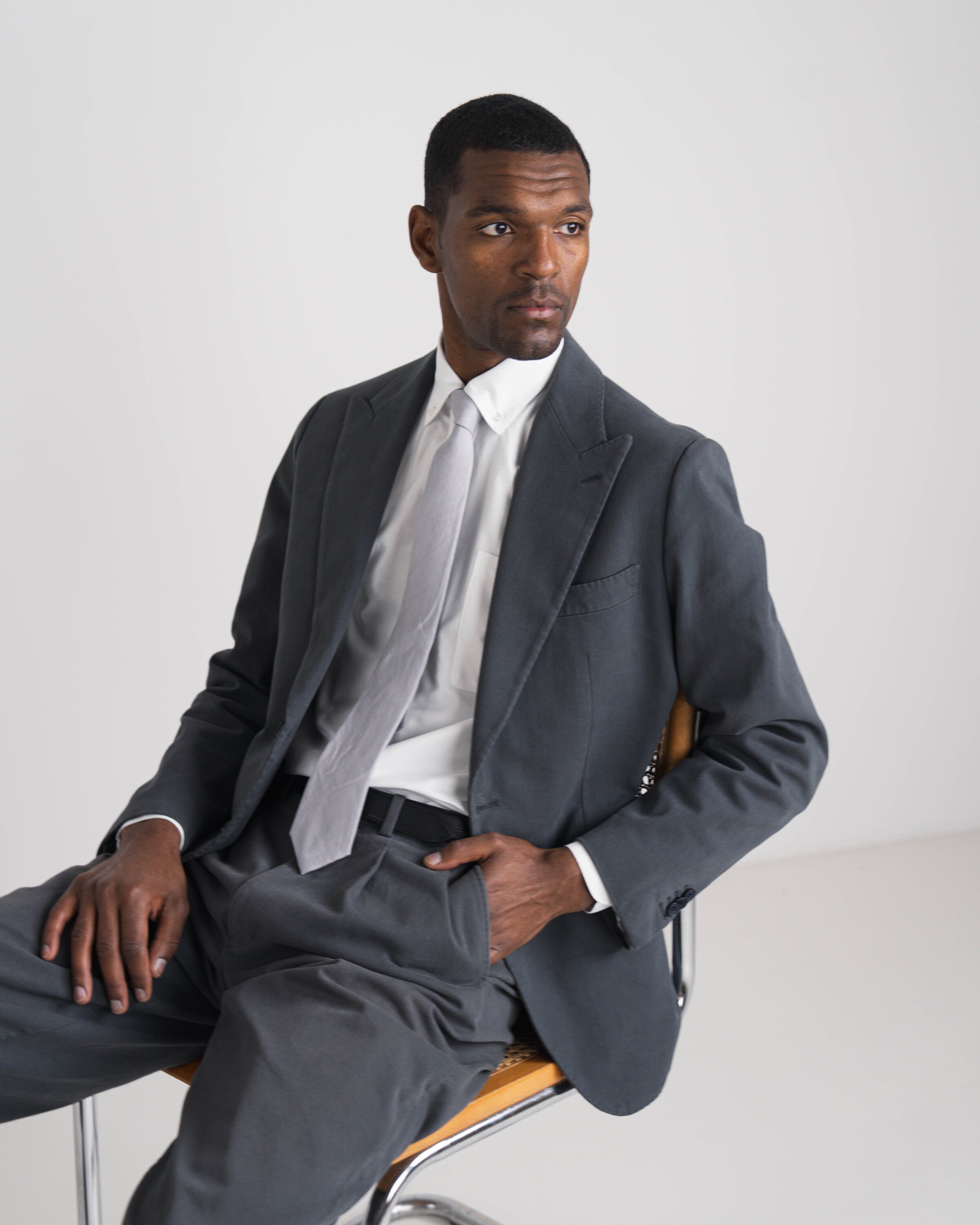 zittende man met grijs pak en lichtgrijze das