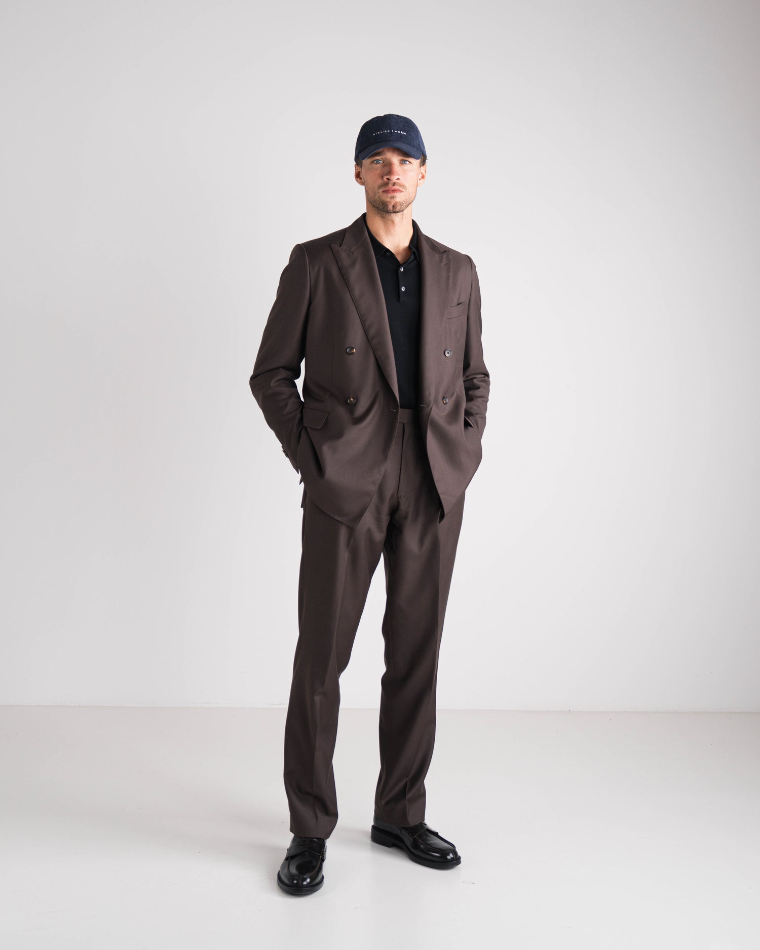man in bruin kostuum met zwarte polo en blauwe pet