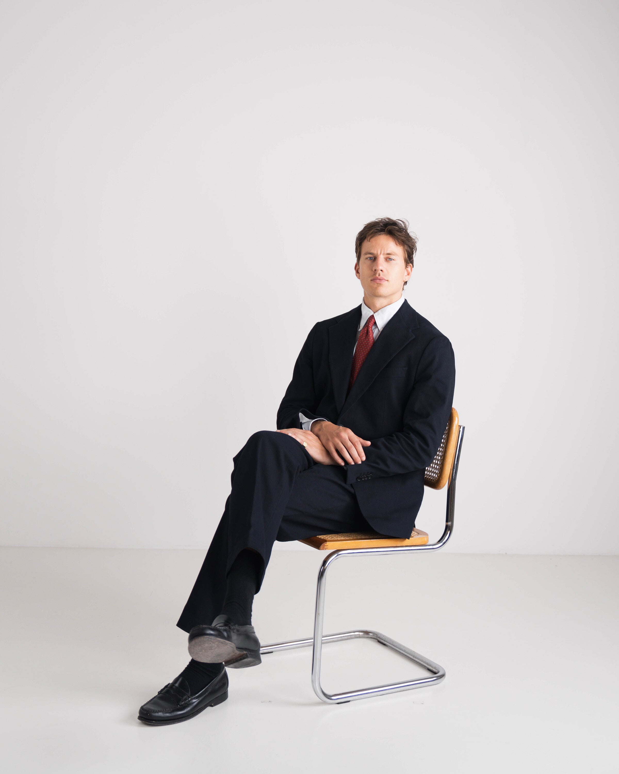 man in blauw kostuum met rode das