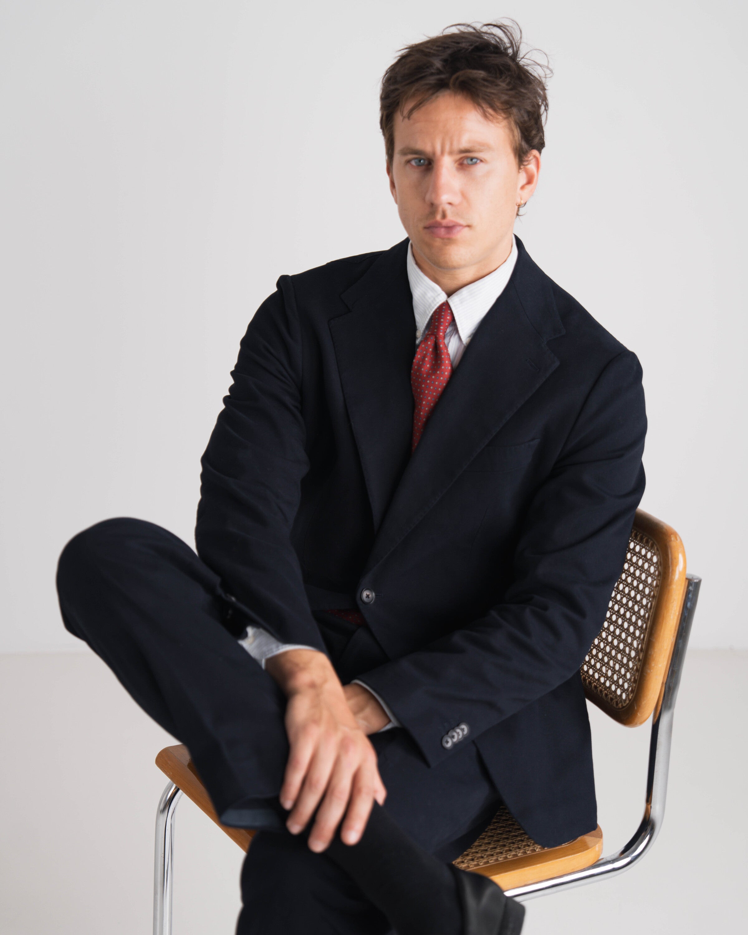 man in blauw kostuum met rode das