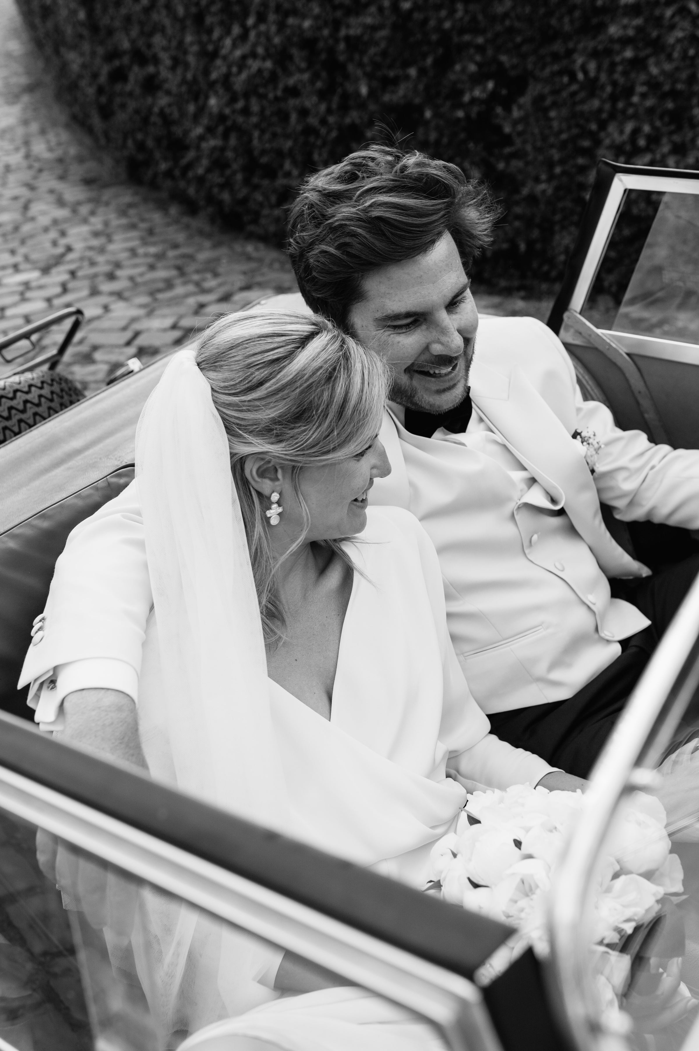 Newlywed couple celebrating, groom in a handcrafted Atelier ACÀN tuxedo.