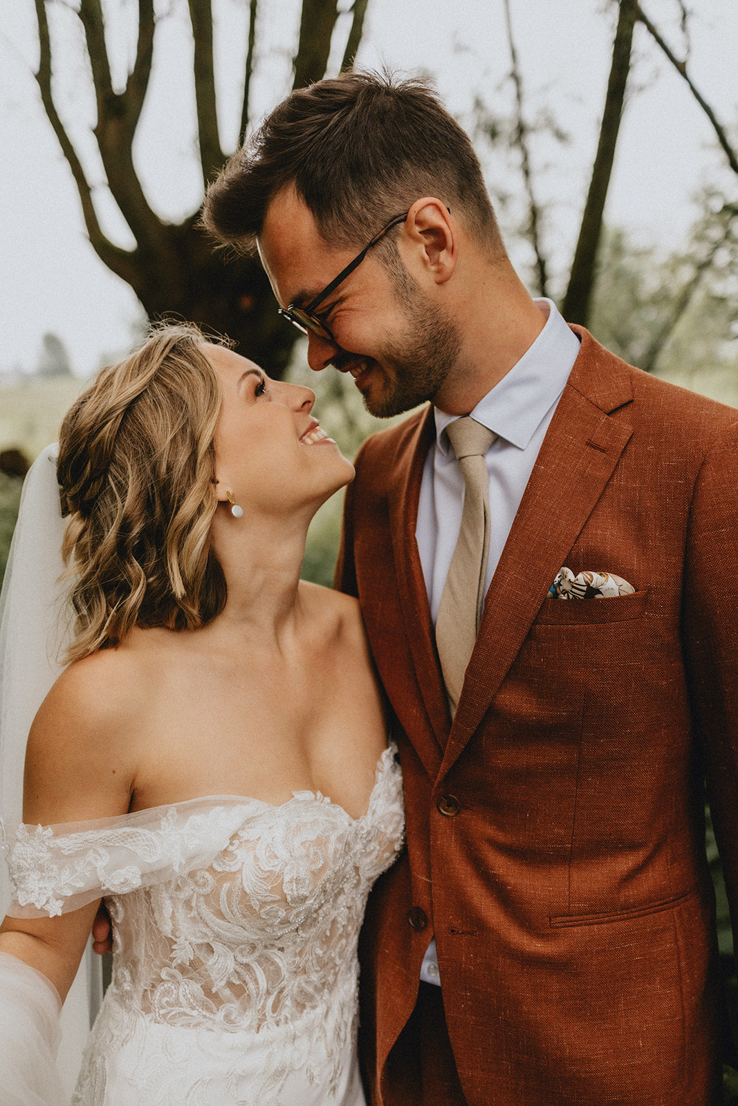Newlywed couple celebrating, groom in a handcrafted Atelier ACÀN tuxedo.