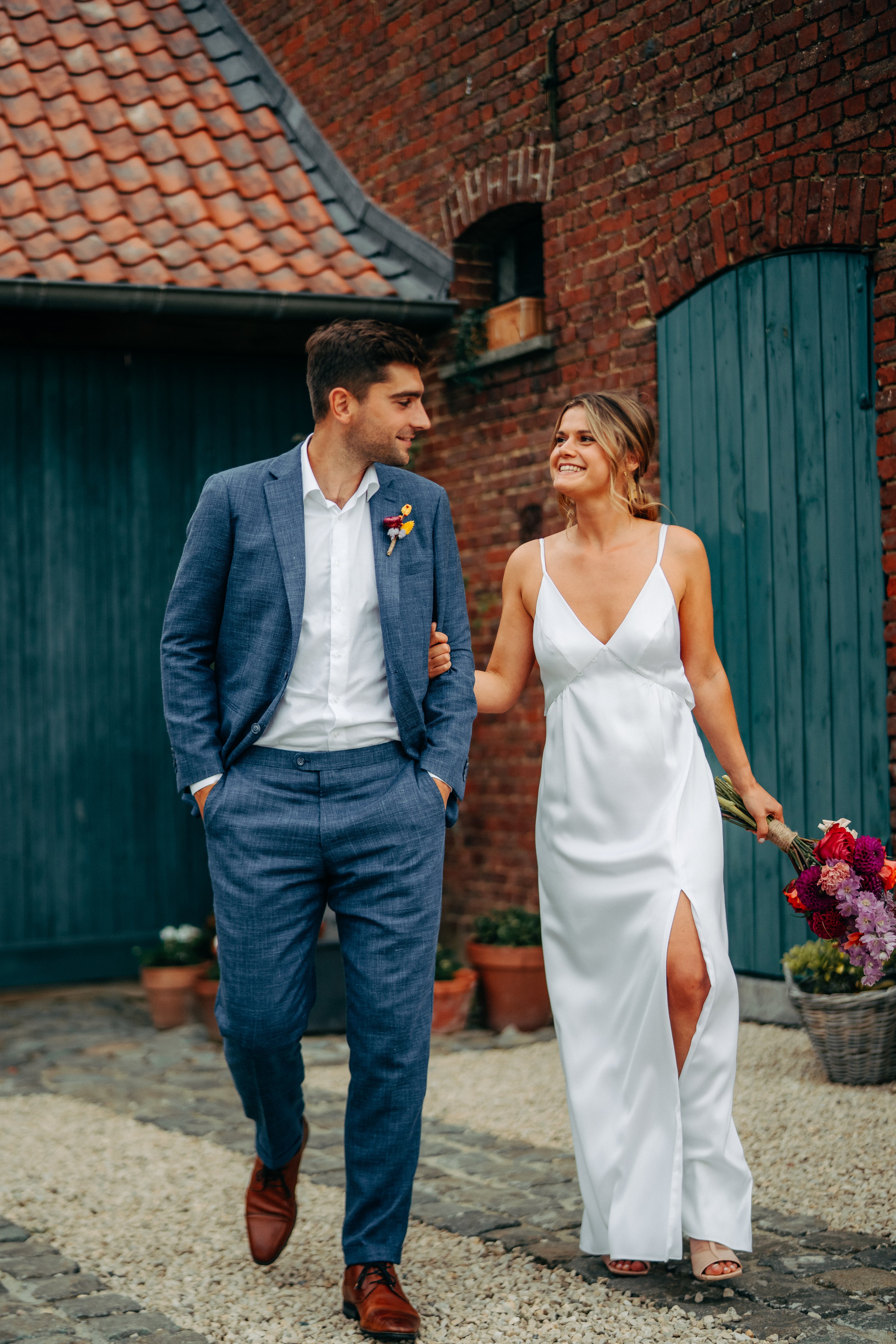 Newlywed couple celebrating, groom in a handcrafted Atelier ACÀN tuxedo.