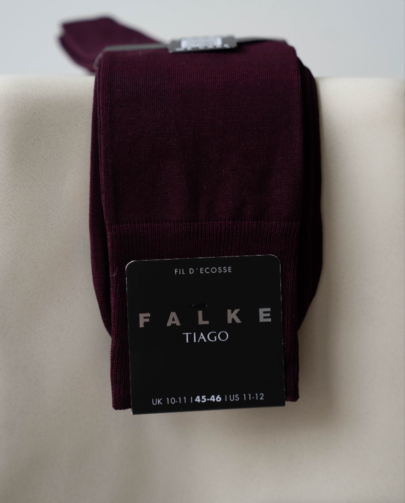 Pair of Falke Tiago socks on a beige surface with a visible brand label.